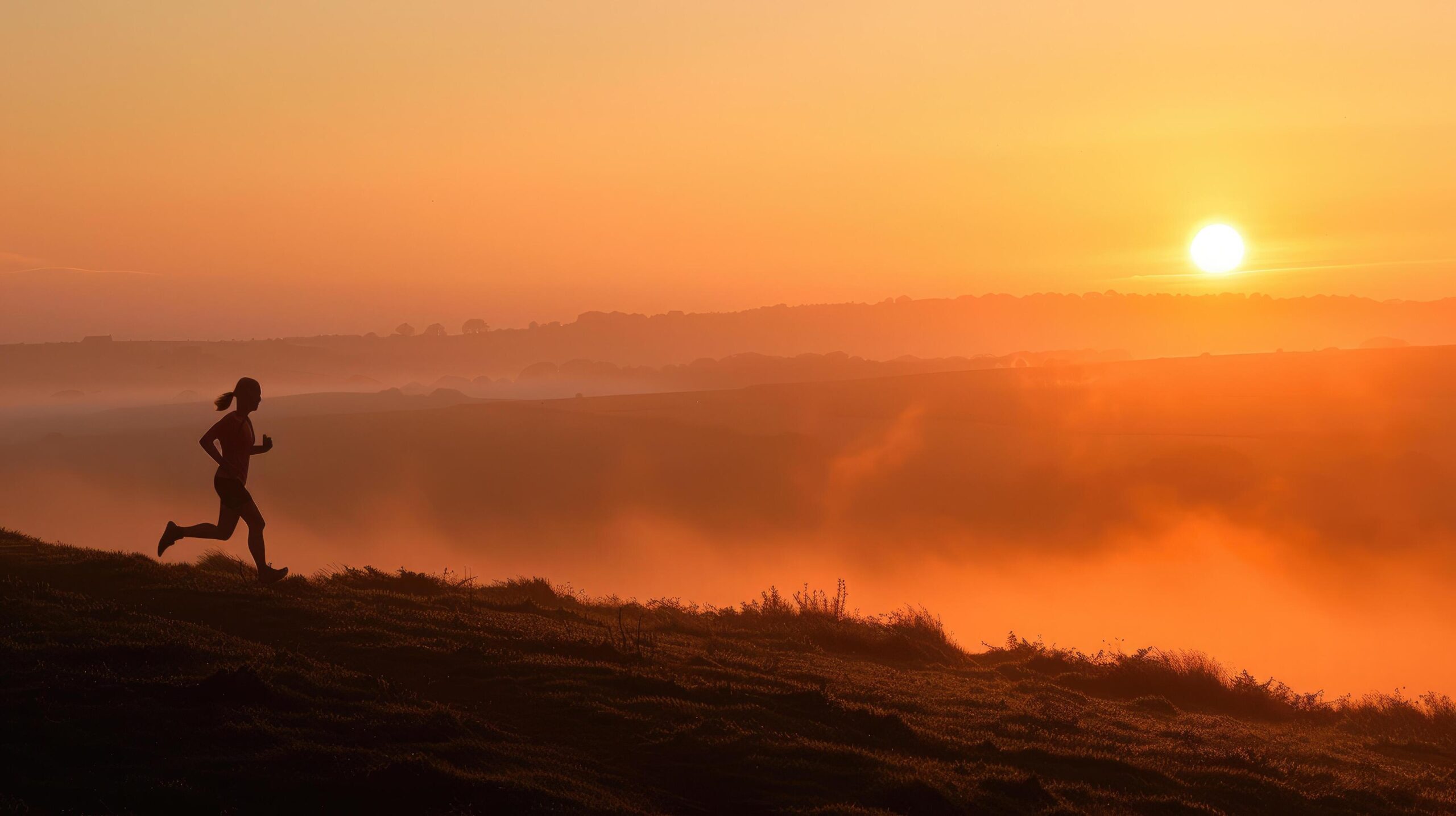 Ai-generated-silhouette-of-a-runner-on-a-misty-hillside-at-sunrise-with-a-warm-orange-sky-free-photo