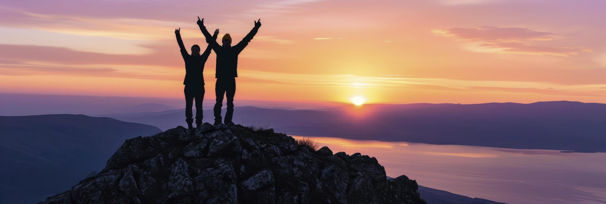 Ai-generated-two-people-silhouette-with-arms-raised-up-on-mountain-top-at-sunset-free-photo