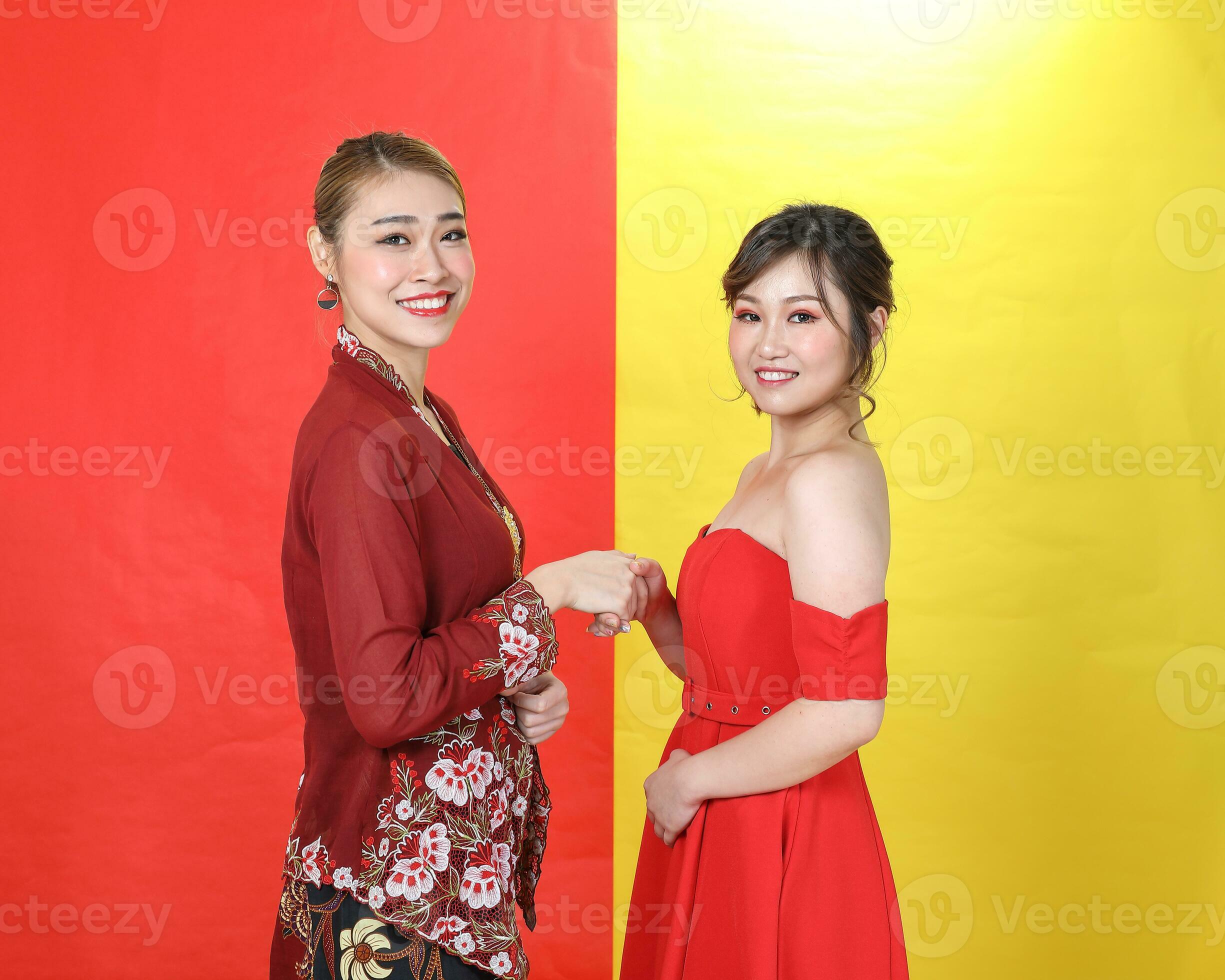 Two-asian-woman-traditional-kebaya-and-modern-dress-red-yellow-paper-background-meet-great-photo
