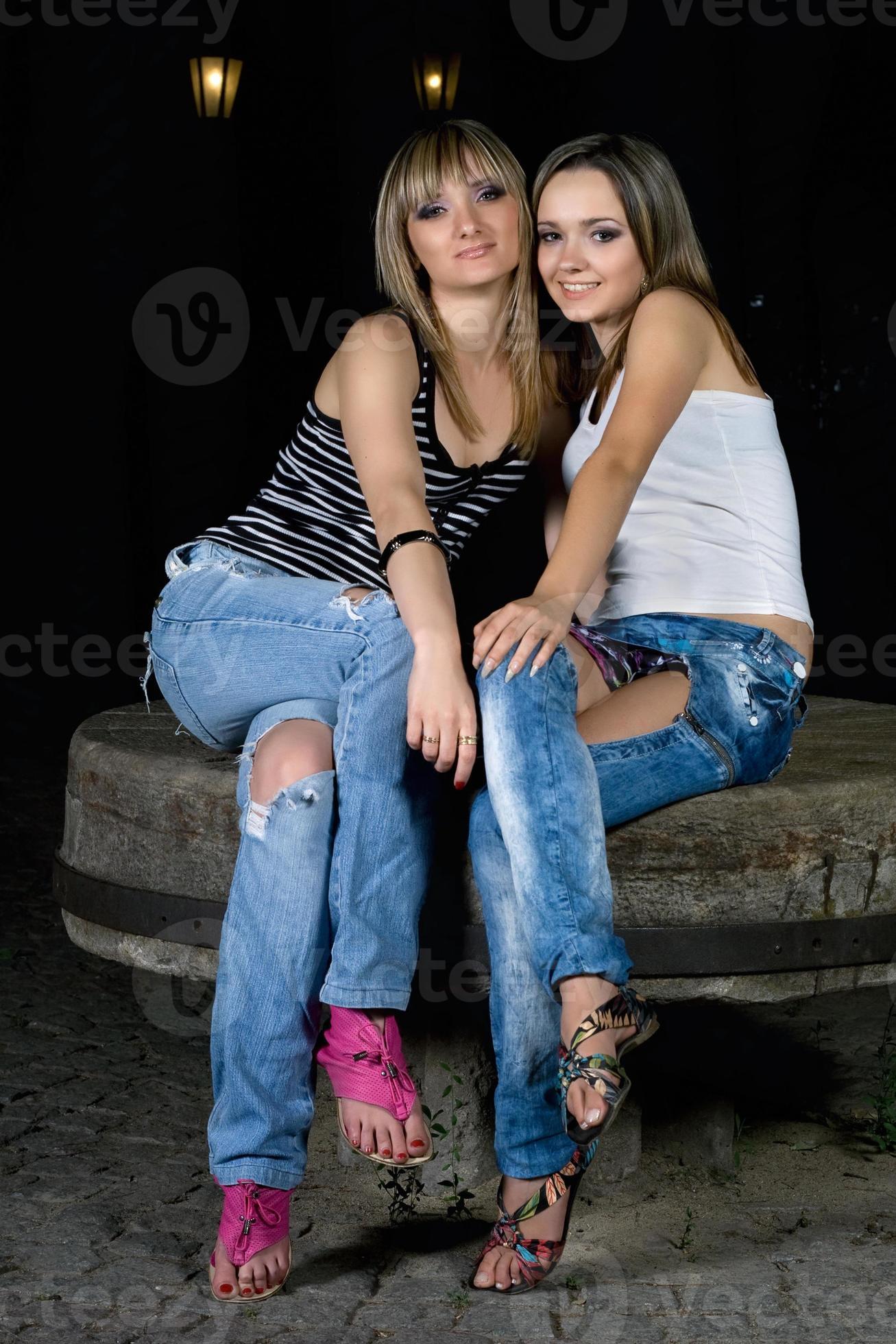 Two-beautiful-girls-sitting-on-a-stone-photo